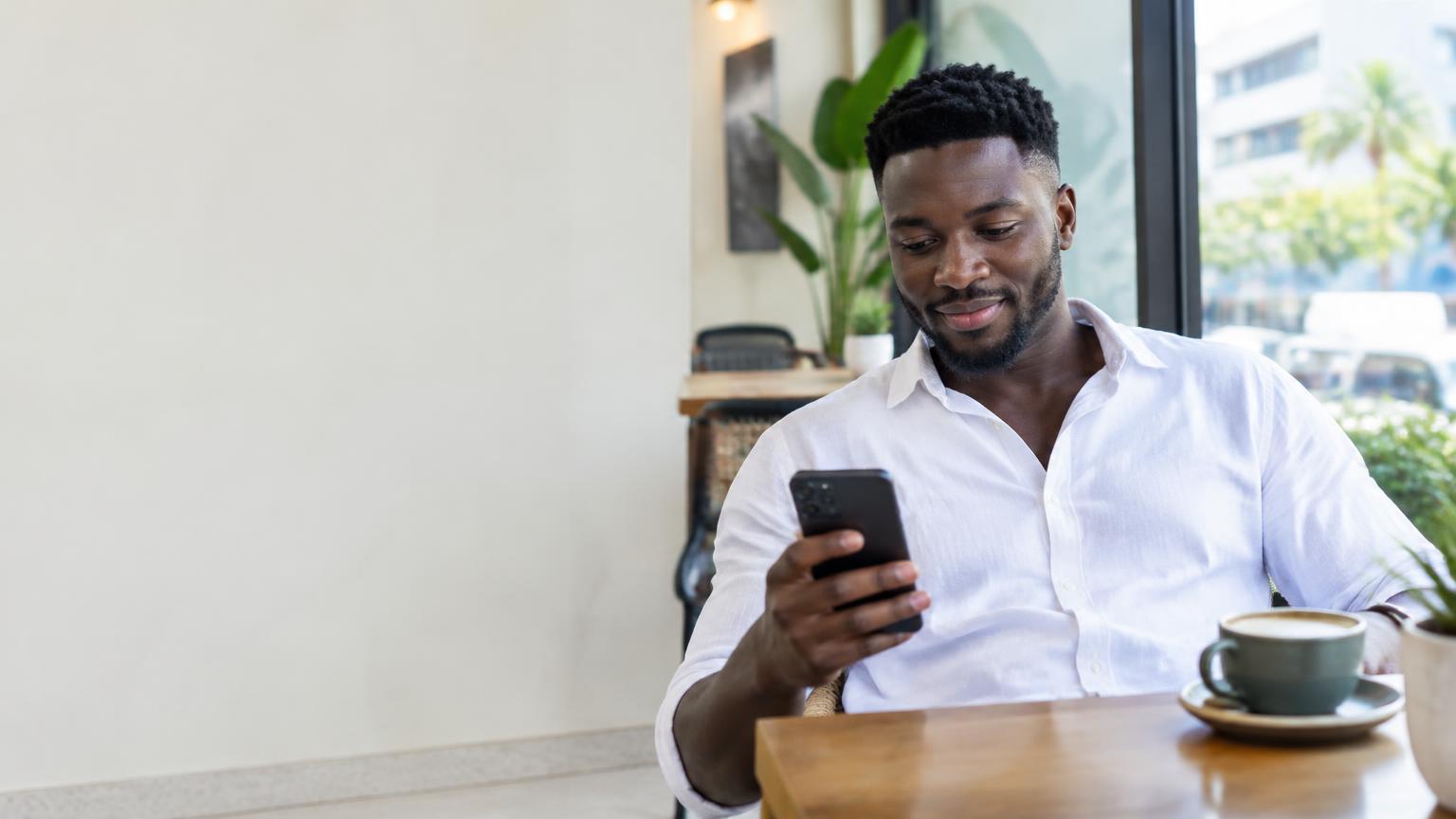 Ghanaian man exploring his phone in an Accra café